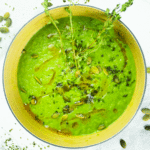 celery_spinach_broccoli_soup Warm green immune-boosting soup in a bowl, garnished with herbs and pumpkin seeds