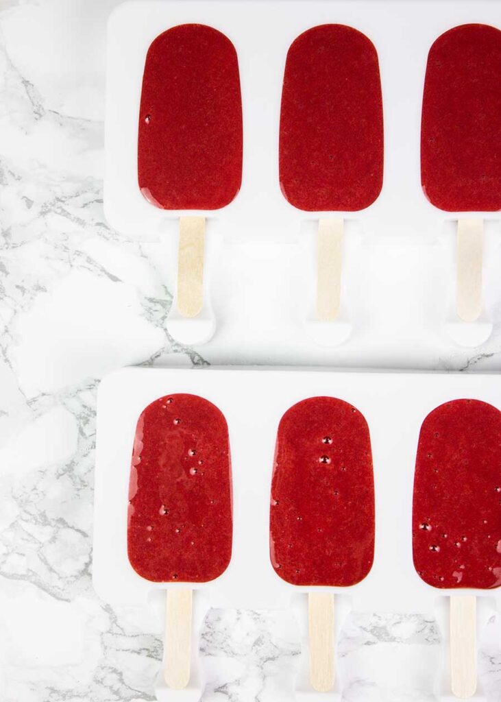 Making homemade strawberry popsicles